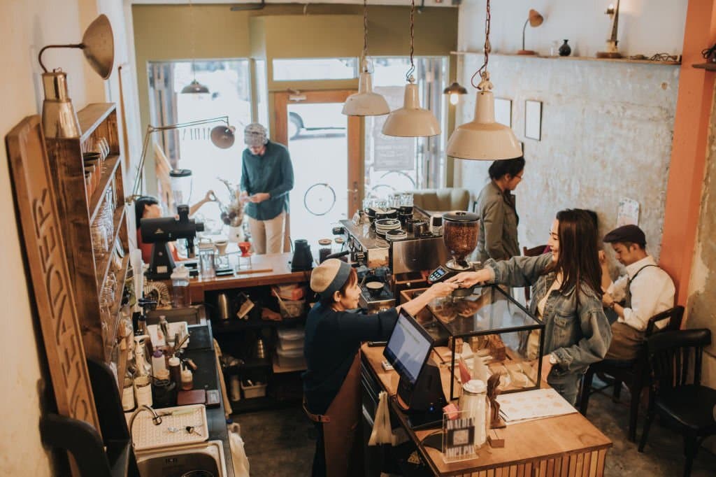 A café owner managing his busy space from his phone